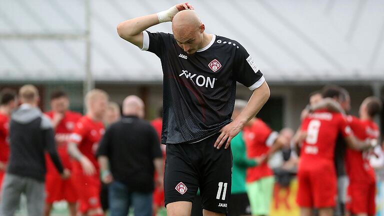 Ein Bild mit Symbolcharakter: Während Kickers-Stürmer Alem Japaur über die Niederlage zu grübeln scheint, feiern im Hintergrund die Buchbacher den 1:0-Sieg.
