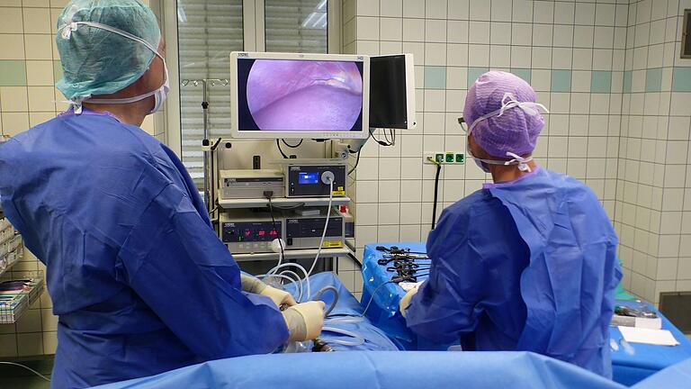 Arzt und Schwester bei laufender OP: Über ein Spezialinstrument kann der Operateur in den Bauch des Patienten sehen. Arzt und Schwester bei laufender OP: Über ein Spezialinstrument kann der Operateur in den Bauch des Patienten sehen.