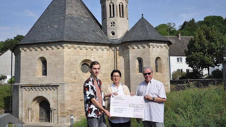 Der Bauförderverein der Kirche will die Achatiuskapelle in Grünsfeld-Hausen barrierefrei ausbauen. Benedikt Gerstner (Jugendbeirat) und Christine Kastner (Kulturverein) überreichen Alfred Beetz einen Scheck von 500 Euro.&nbsp;