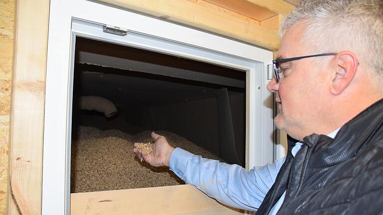 Gut gefüllt ist das Pelletlager im Keller des Hambacher Pfarrhauses, wie Bürgermeister Willi Warmuth feststellt.