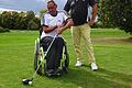 Achim Ankenbrand zeigt zusammen mit Frank Sorber (rechts), dass es unmöglich ist, aus einem normalen Rollstuhl Golf zu spielen.