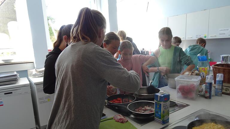 Schülerinnen beim Braten von Speck und Tomaten sowie Zubereiten des „French Toasts“. Schülerinnen beim Braten von Speck und Tomaten sowie Zubereiten des „French Toasts“.