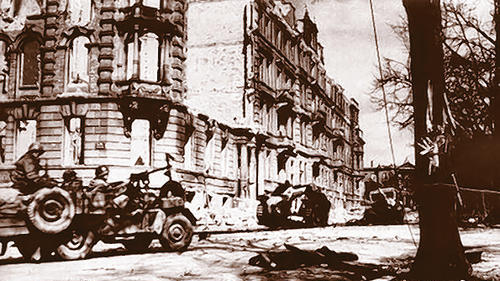 Ein US-Jeep fährt am Sanderring auf einen abgeschossenen Wehrmachtspanzer zu. Ein US-Jeep fährt am Sanderring auf einen abgeschossenen Wehrmachtspanzer zu.
