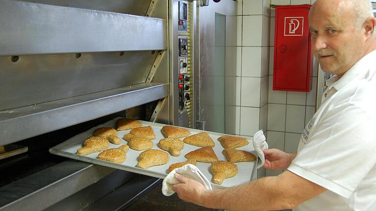 Walter Emmert mit legendären Dätschern auf dem Backblech.