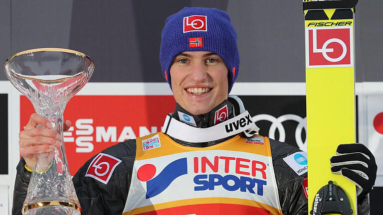 Sieger       -  Der Norweger Daniel Andre Tande jubelt mit der Trophäe nach seinem Sieg beim Springen von der Bergisel-Schanze. Foto Daniel Karmann Foto: Daniel Karmann