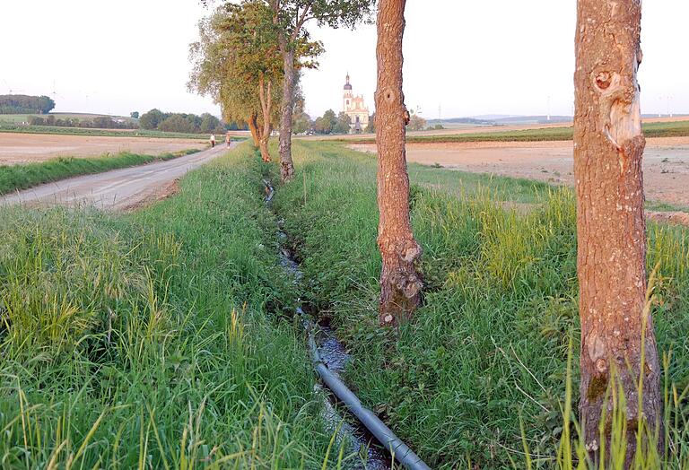 Die Pleichach an ihrem Oberlauf kurz vor dem Weiler Fährbrück zehn Tage nach dem Unwetter. Der Feldweg und die Felder rechts und links zeugen noch vom starken Regen und den Überschwemmungen.