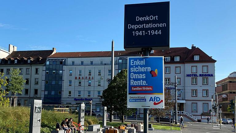 Das AfD-Wahlkplakat - direkt unter dem Hinweisschild auf den DenkOrt Deportationen am Mittwochabend am Bahnhofsvorplatz in Würzburg. Das AfD-Wahlkplakat - direkt unter dem Hinweisschild auf den DenkOrt Deportationen am Mittwochabend am Bahnhofsvorplatz in Würzburg.
