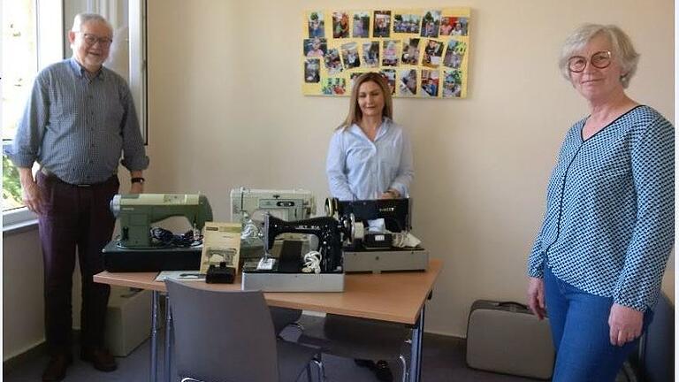 Günther Rösch und Sakine Azodanlou  freuen sich über die Nähmaschinen, die dem Helferkreis von Bernadette Cosanne (rechts) übergeben wurden. Die Masken wurden nur kurz für das Foto abgenommen.