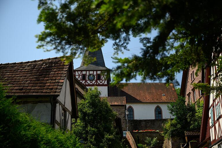 Fachwerk prägt das Ortsbild von Dertingen. Im Hintergrund ragt der Turm der Wehrkirche auf.