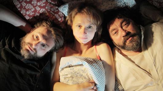 Alki Alki - Eine Szene aus „Alki Alki“: Die Sucht wird im Film durch „Flasche“ (Peter Trabner, links), den imaginären Freund des Protagonisten Tobias (Heiko Pinkowski, rechts) dargestellt. Selbst wenn Tobias mit seiner Frau Anika (Christina Große) im Bett liegt, ist „Flasche“ dabei. Alki Alki - Eine Szene aus „Alki Alki“: Die Sucht wird im Film durch „Flasche“ (Peter Trabner, links), den imaginären Freund des Protagonisten Tobias (Heiko Pinkowski, rechts) dargestellt. Selbst wenn Tobias mit seiner Frau Anika (Christina Große) im Bett liegt, ist „Flasche“ dabei.