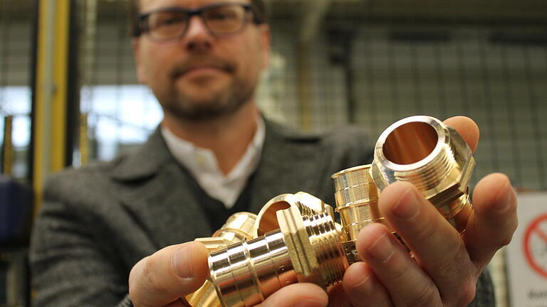 Uponor GmbH in Haßfurt: Solche Fittings, also Verbindungsstücke für Rohre, stellt Uponor in Haßfurt her - 40 Millionen pro Jahr. Fabrikleiter Stefan Endres zeigt sie.