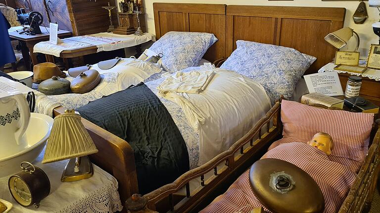 Ein Ehebett mit Kinderwiege, nebst mehreren Wärmflaschen. Ein Ehebett mit Kinderwiege, nebst mehreren Wärmflaschen.