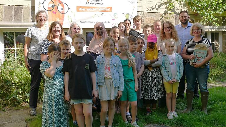 Schülerinnen und Schüler der Gemüseackerdemie, Frau Dotzel-Morche, Frau Heck (Betreuerinnen der Gartengruppe), Frau Pensel, Schulleiterin der Dr. Pfeiffer Grundschule, Frau Zink, Leiterin der Pestalozzi-Schule, Herr Toprak, der Vertreter der AOK und Frau Listmann von Acker e.V.