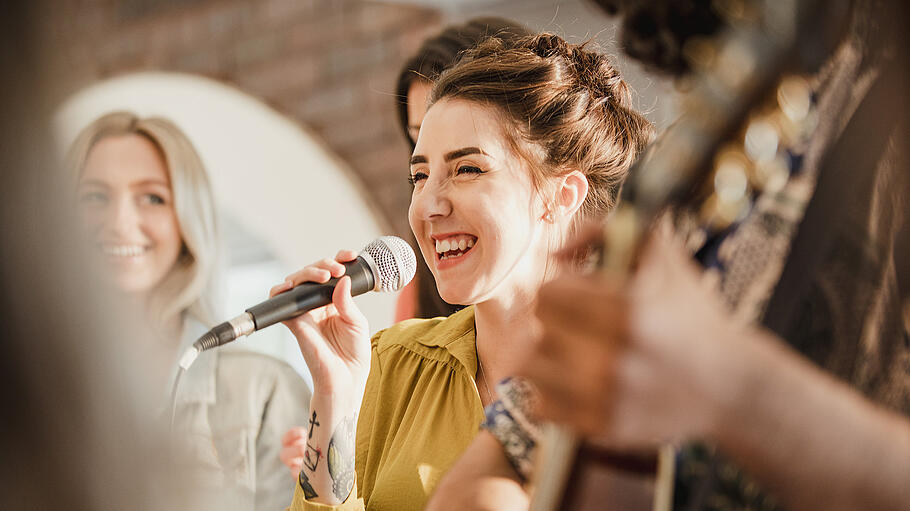 Fun Wedding Entertainers       -  Entertianment at a wedding. A female singer is interacting with the crowd while a man plays an acoustic guitar.