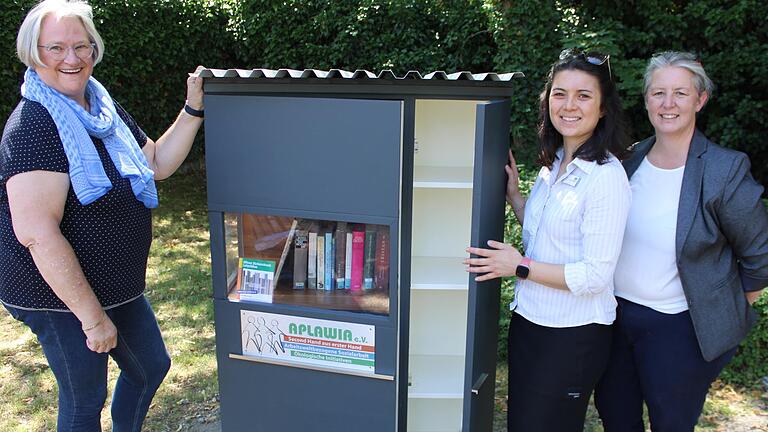 Präsentieren den neuen öffentlichen Bücherschrank im kleinen Garten neben dem Luitpoldbau: Bürgermeisterin Astrid Glos, Büchereileiterin Sheena Ulsamer und Sandra Pfannes von Aplawia.