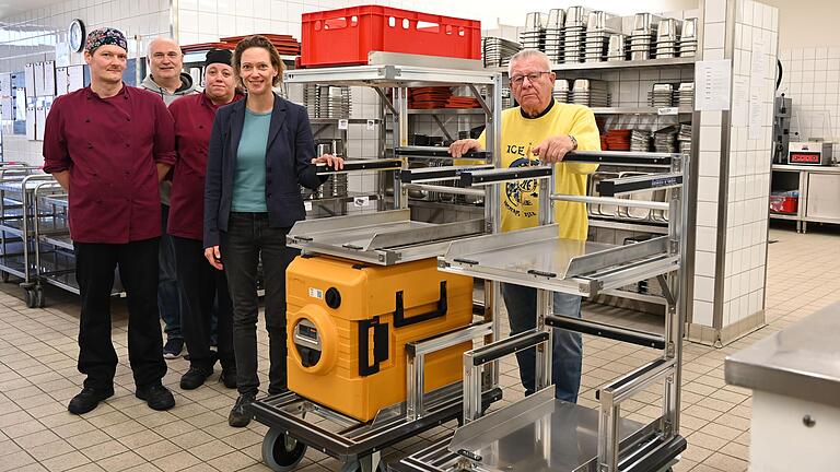 Die Mitarbeiter der Küche im St. Josefs-Stift (von links), Ines Hensel (Geschäftsführerin der Frma Hensel) und Ernst Hestermann (Vorsitzender des St. Josefs-Stifts e. V.) freuen sich über die Rollwagen.
