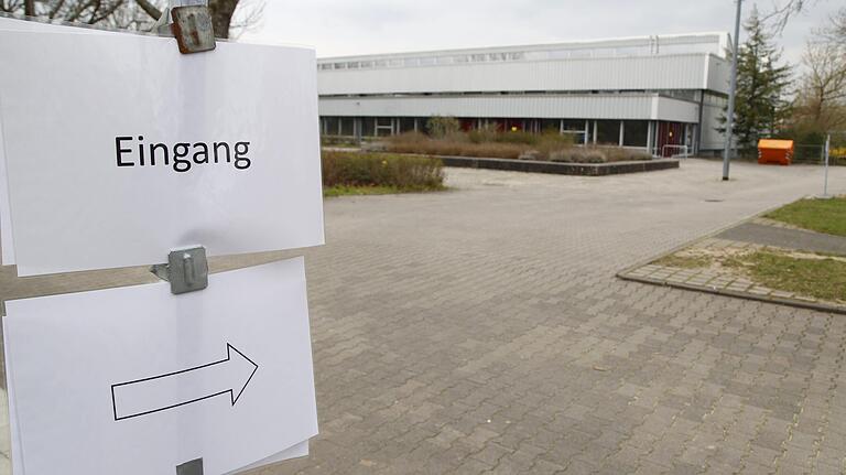 Das Schild weist den zu testenden Personen an der Teststrecke am Humboldt-Gymnasium den Weg zum Eingang.