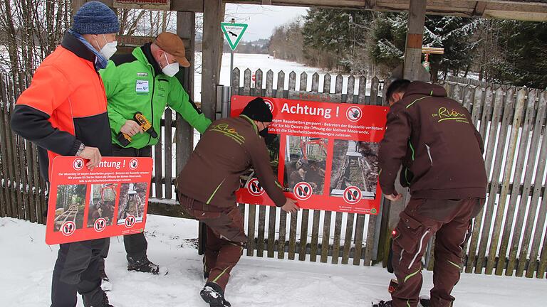 Am Eingang zum Schwarzen Moor beobachteten (von links) Naturpark-Geschäftsführer Klaus Spitzl und Gebietsbetreuer Torsten Kirchner, wie Christof Schlott und Thomas Städtler eines der neuen Verbotsschilder anbringen.