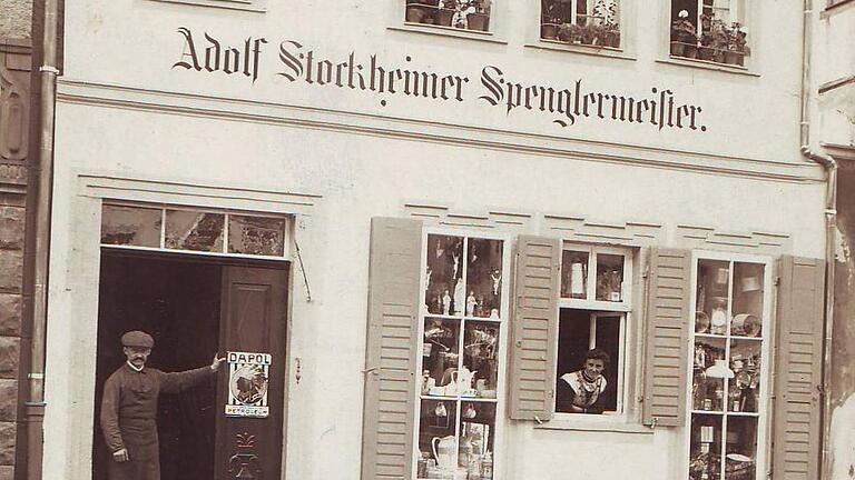 Adolf Stockheimer (in der Tür) eröffnete im April 1912 das Haushaltswarengeschäft mit Spenglerei in der Bahnhofstraße 43 in Hammelburg. Die stolze Gattin Karolina schaut aus dem Fenster.       -  Adolf Stockheimer (in der Tür) eröffnete im April 1912 das Haushaltswarengeschäft mit Spenglerei in der Bahnhofstraße 43 in Hammelburg. Die stolze Gattin Karolina schaut aus dem Fenster.