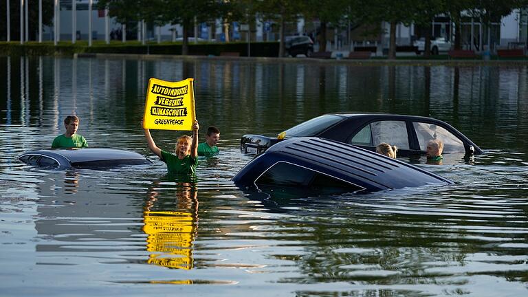 IAA - Greenpeace-Aktion.jpeg       -  Aktivistinnen und Aktivisten von Greenpeace demonstrieren bei der IAA in München im See vor dem Haupteingang.