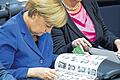Blättern in der Bundestagsliste: Angela Merkel schaut sich Bilder der Parlamentarier an.
