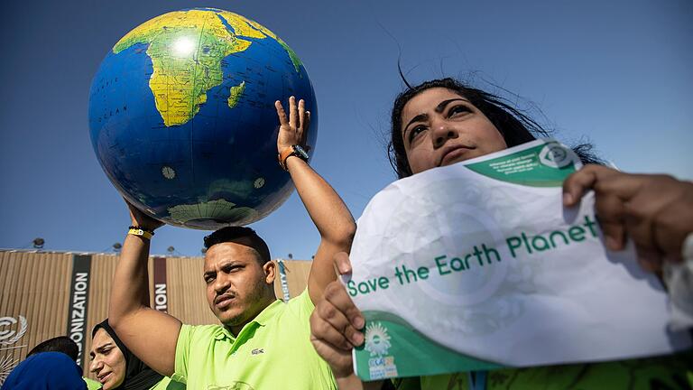 Wie lässt sich die Klimakatastrophe global noch aufhalten? Demonstrierende halten anlässlich der Weltklimakonferenz in Ägypten eine Weltkugel hoch. Wie lässt sich die Klimakatastrophe global noch aufhalten? Demonstrierende halten anlässlich der Weltklimakonferenz in Ägypten eine Weltkugel hoch.