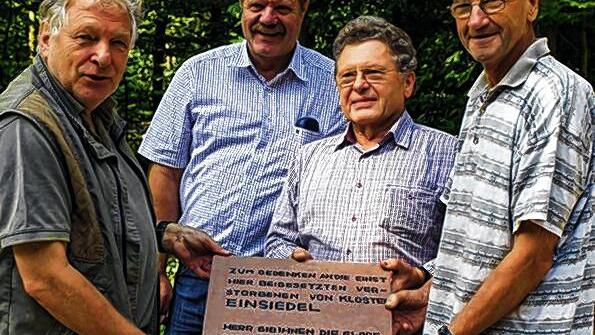 Gedenktafel: Als Dank für die Führung und zur Erinnerung überreichte Rienecks Bürgermeister Wolfgang Küber den Vorsitzenden der Arbeitsgemeinschaft Kloster Einsiedel und des Ruppertshüttener Geschichtsvereins, Lorenz Ringel und Ingbert Roth, sowie dem besonders engagierten Grabungshelfer Horst Reinhard eine Gedenktafel. Gefertigt hat sie der Rienecker Walter Konrad zum Gedenken an die Verstorbenen des Klosters.