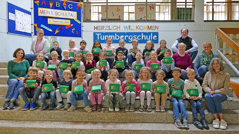 Die beiden Eingangsklassen der Turmbergschule freuten sich über die praktische Lunchbox, die Bürgermeister&nbsp; Lukas Braun (rechts hinten), Fachbereichsleiterin Sabine Baumeister und stellvertretende Sachgebietsleiterin Melanie Hofmann (rechts) zum Schuljahresbeginn überreichten. Auch die Leiterin der Turmbergschule Katharina Ott (links oben) und die Klassenlehrerinnen Sibylle Fischer (links) und Anja Muthig (rechts) waren vom Besuch des Bürgermeisters sehr erfreut.