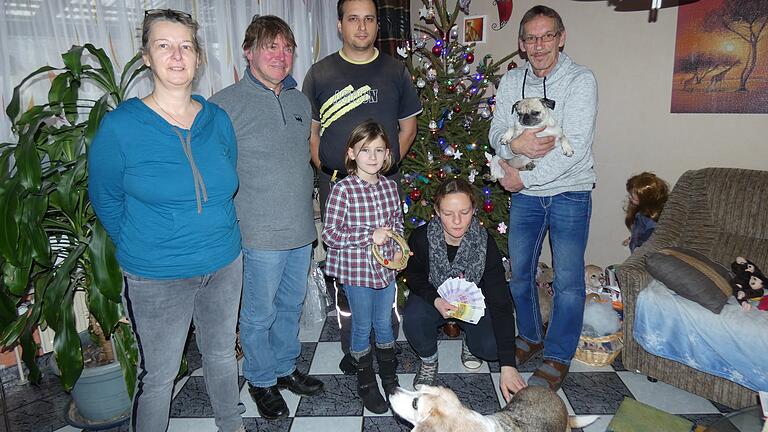 Peter (rechts) und Evi (links) Mack konnten in diesem Jahr aus dem Erlös des Weihnachtshauses die Summe von 4200 Euro an den Tierschutzhof in Großeibstadt übergeben. Darüber freuten sich (von links) Thomas Draxler, Roberto Wiegler und (kniend) Franziska Dorsch, die den Geldsegen in Händen hält. Charlotte, die ab und zu auf dem Tierschutzhof reitet, hält das Hufeisen als Glücksbringer in der Hand. Natürlich durften Beagle Evelyne und Mops Mia nicht fehlen.