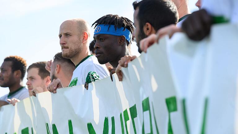 Osaivbie Ekogiawe, genannt Kelvin, aus Würzburg muss weiter um sein Bleiberecht kämpfen. Das Bild zeigt ihn mit seinen Mitspielern beim SV Heidingsfeld hinter einem Banner, mit dem sie beim Fußballspiel am vergangenen Sonntag auf die drohende Abschiebung des 20-Jährigen aufmerksam machten. Osaivbie Ekogiawe, genannt Kelvin, aus Würzburg muss weiter um sein Bleiberecht kämpfen. Das Bild zeigt ihn mit seinen Mitspielern beim SV Heidingsfeld hinter einem Banner, mit dem sie beim Fußballspiel am vergangenen Sonntag auf die drohende Abschiebung des 20-Jährigen aufmerksam machten.