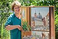 Sigrid Mahsberg mit dem Bild des Malers Hermann Strobl, das den Blick aus dem ersten Stock des Cafés zeigt.