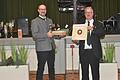 Schützenmeister Harald Gretsch (rechts) überreicht seinem Amtskollegen Michael Rauschmeier aus Emmering ein Weingeschenk und einen finanziellen Beitrag für den Einbau elektronischer Schiessstände.