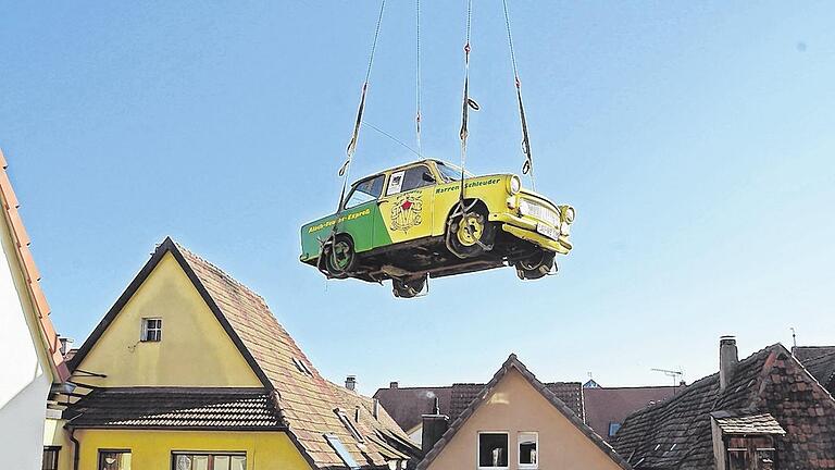 Kommt ein Trabbi geflogen . . .       -  Er wird Narrenschleuder genannt, oder einfach &bdquo;Narren &ndash; Trabbi&ldquo; und gehört dem Deutschen Fastnachtmuseum. Während der Bauphase war der Trabant im Kitzinger Bauhof untergebracht. Jetzt schwebte er mit Hilfe eines Krans über das Museum in den Innenhof auf die Terrasse ein.