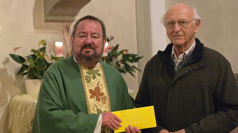 Hubert Kuhn (rechts) übergibt an Pfarrer Michael Erhart die Spende des Obst- und Gartenbauvereins Zeil aus der Kräuterbüschelaktion.