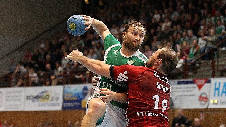 DKB 2. Handball-Bundesliga, DJK Rimpar Wölfe -VfL Lübeck-Schwartau       -  Körperkontakt: Rimpars Stefan Schmitt (am Ball) legt sich gegen Lübecks Jan Schult ins Zeug.