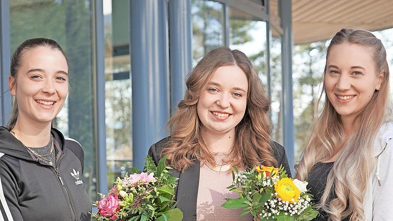 Johanna Schmitt (Mitte) aus der Personalabteilung überreicht Linda Rauch (links) und Laura Kaßecker (rechts) einen Blumenstrauß.       -  Johanna Schmitt (Mitte) aus der Personalabteilung überreicht Linda Rauch (links) und Laura Kaßecker (rechts) einen Blumenstrauß.