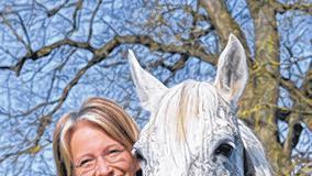 Landoberstallmeisterin Astrid von Velsen-Zerweck steht im Haupt-und Landgestüt auf einer Koppel mit einem Vollblutaraber.