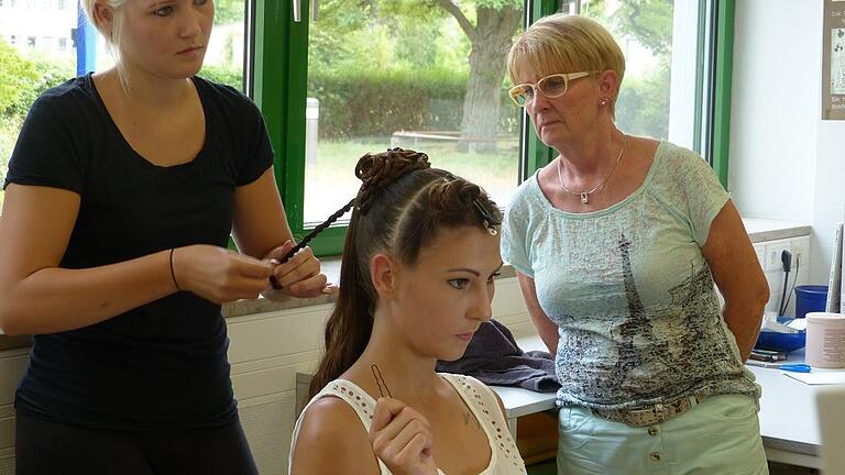 Praktische Gesellenprüfung der Friseure: Unter den wachsamen Augen der Prüfungsvorsitzenden Ute Lang (rechts) entsteht in der Berufsschule Karlstadt eine festliche Hochsteckfrisur.