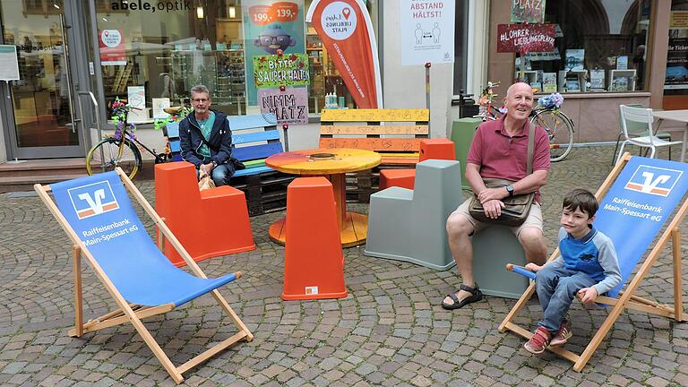 Ein Tourist aus Gießen (links) und der fünf-jährige Oskar und sein Opa aus Würzburg genießen den 'Lieblingsplatz' in der Lohrer Fußgängerzone.