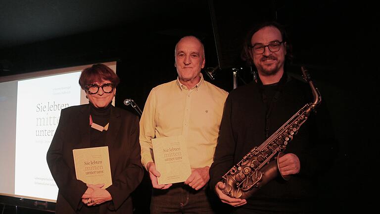 Die Autoren Johanna Bonengel und Hannes Helferich des Werkes 'Sie lebten mitten unter uns' bei der offiziellen Buchvorstellung in der Disharmonie an der Seite von Saxophonist Anton Mangold, der für den musikalischen Rahmen sorgte.