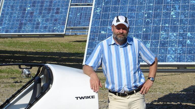 Hans-Josef Fell im Jahr 2005 mit seinem Twike in Arnstein am damals weltgrößten Solarpark. Foto: Archiv Fell       -  Hans-Josef Fell im Jahr 2005 mit seinem Twike in Arnstein am damals weltgrößten Solarpark. Foto: Archiv Fell