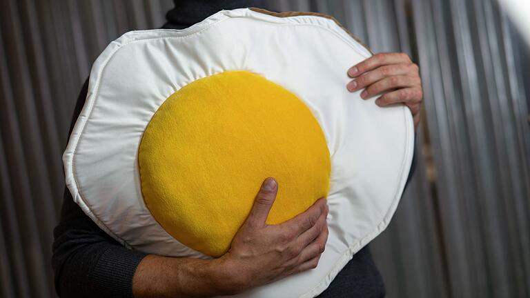 Kuschelobjekte für Erwachsene - Ei, ei, ei: Ein Hingucker ist dieses flauschige Spiegelei aus Baumwolle, Schaumstoff und Polyesterfasern. Kuschelobjekte für Erwachsene - Ei, ei, ei: Ein Hingucker ist dieses flauschige Spiegelei aus Baumwolle, Schaumstoff und Polyesterfasern.