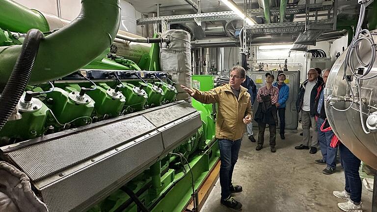 Beim Rundgang in der Anlage zeigte Mathias Klöffel  das große, einem Schiffsmotor vergleichbaren, Blockheizkraftwerk.