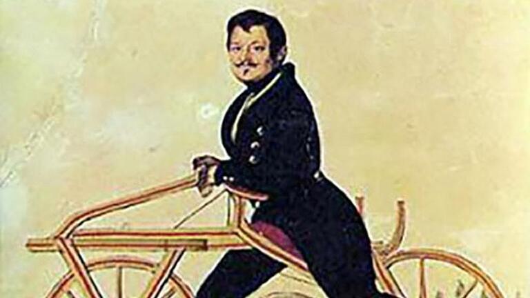 Freiherr Karl von Drais mit seiner Laufmaschine aus dem Jahr 1817.