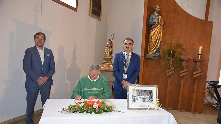 Pfarrer Dominik Kesina (Mitte) trägt sich ins Goldene Buch der Gemeinde Nüdlingen ein, mit dabei 2. Bürgermeister Edgar Thomas (links) und 1. Bürgermeister Harald Hofmann (rechts). Fotos: Artur Stollberger - Pfarrer Dominik Kesina (Mitte) trägt sich ins Goldene Buch der Gemeinde Nüdlingen ein, mit dabei 2. Bürgermeister Edgar Thomas (links) und 1. Bürgermeister Harald Hofmann (rechts). Fotos: Artur Stollberger Pfarrer Dominik Kesina (Mitte) trägt sich ins Goldene Buch der Gemeinde Nüdlingen ein, mit dabei 2. Bürgermeister Edgar Thomas (links) und 1. Bürgermeister Harald Hofmann (rechts). Fotos: Artur Stollberger - Pfarrer Dominik Kesina (Mitte) trägt sich ins Goldene Buch der Gemeinde Nüdlingen ein, mit dabei 2. Bürgermeister Edgar Thomas (links) und 1. Bürgermeister Harald Hofmann (rechts). Fotos: Artur Stollberger
