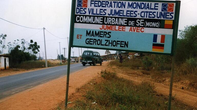 he Se Schild       -  Das Ortsschild der rund 90 Kilometer nördlich von Benins Regierungssitz Cotonou gelegenen Stadt Se verweist auf die Dreieckspartnerschaft mit Gerolzhofen und seiner französischen Partnerstadt Mamers.