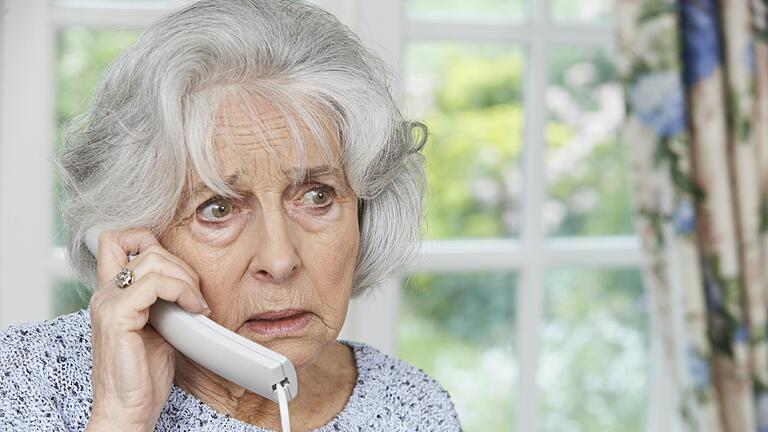 Worried Senior Woman Answering Telephone At Home, enkeltrick