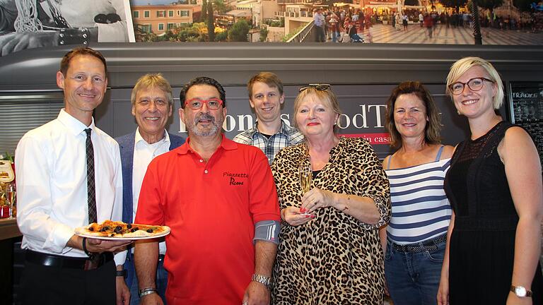 Über die Eröffnung des italienischen Foodtrucks im Rewe-Markt mit dem Namen 'Piazzetta Picone'&nbsp; freuen sich (im Bild von links): Bürgermeister Thorsten Wozniak, Günter Götzelmann, Giovanni Picone, Kai Götzelmann, Doris Leimbigler-Picone, sowie Margit Götzelmann und Nora Götzelmann.