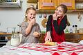 Zwei Mädchen backen Plätzchen       -  Sicherer Genuss: Vegane Rezepte enthalten keine rohen Eier und sind somit ideal für kleine Naschkatzen.