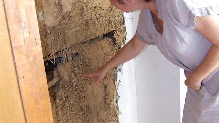 Wasserschaden: Brigitta Böhme zeigt Mängel in den Lehmwänden.
